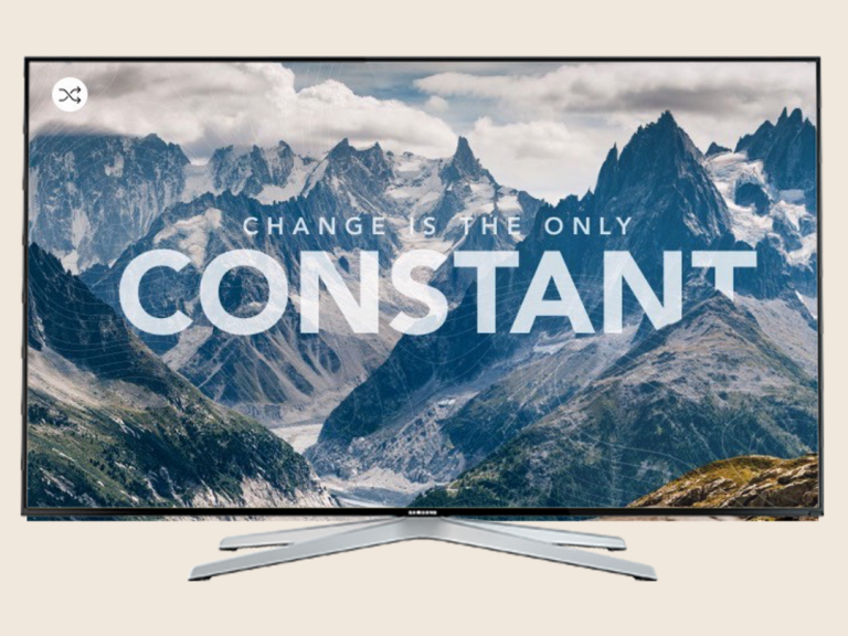 A television displaying the text "Change is the only constant" over a mountain landscape.