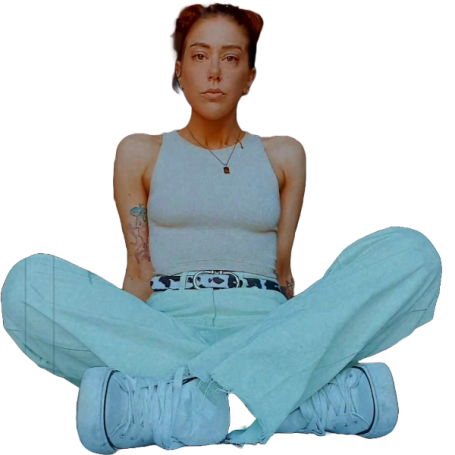 Young woman sitting cross-legged, wearing casual attire with a light blue outfit and white sneakers.